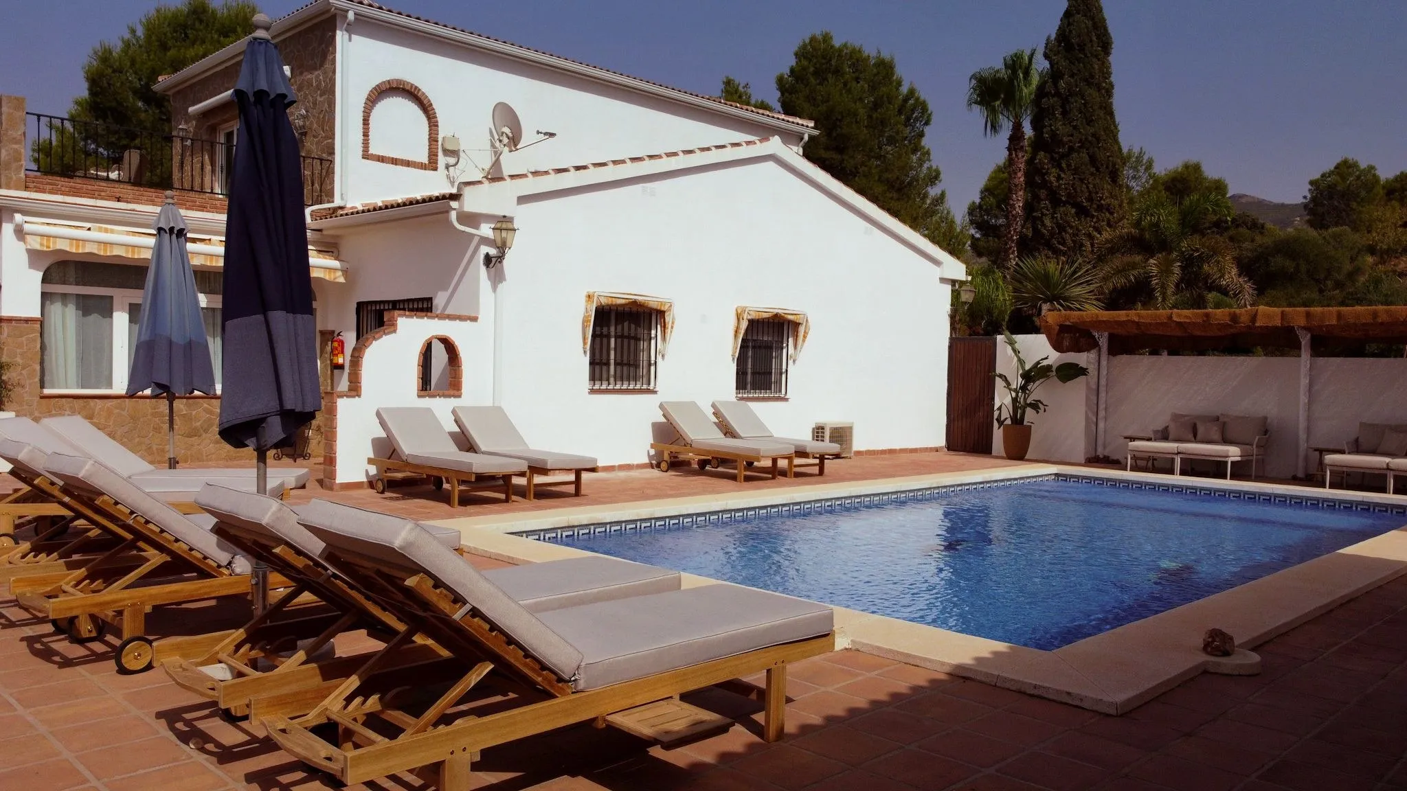 The pool and sun loungers in the afternoon sun